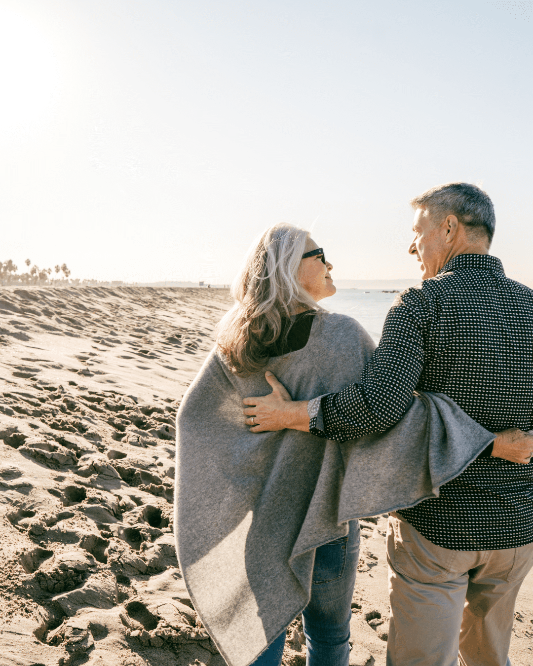couple walking on a beach, retired
